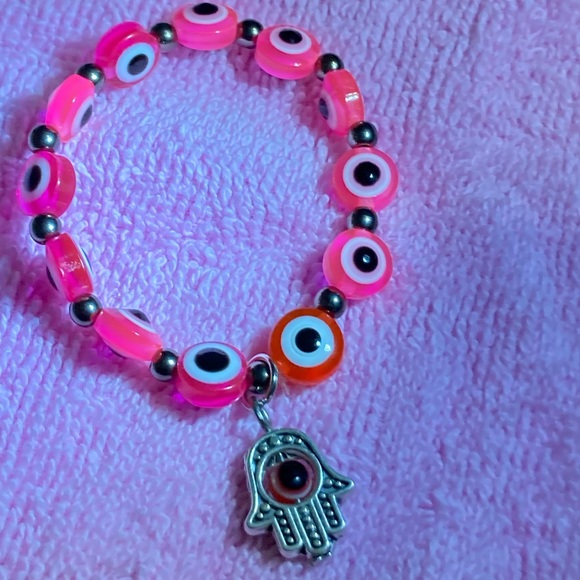 The color is Pink The design includes a hand charm abs a evil eye charm - Picture 1 of 4